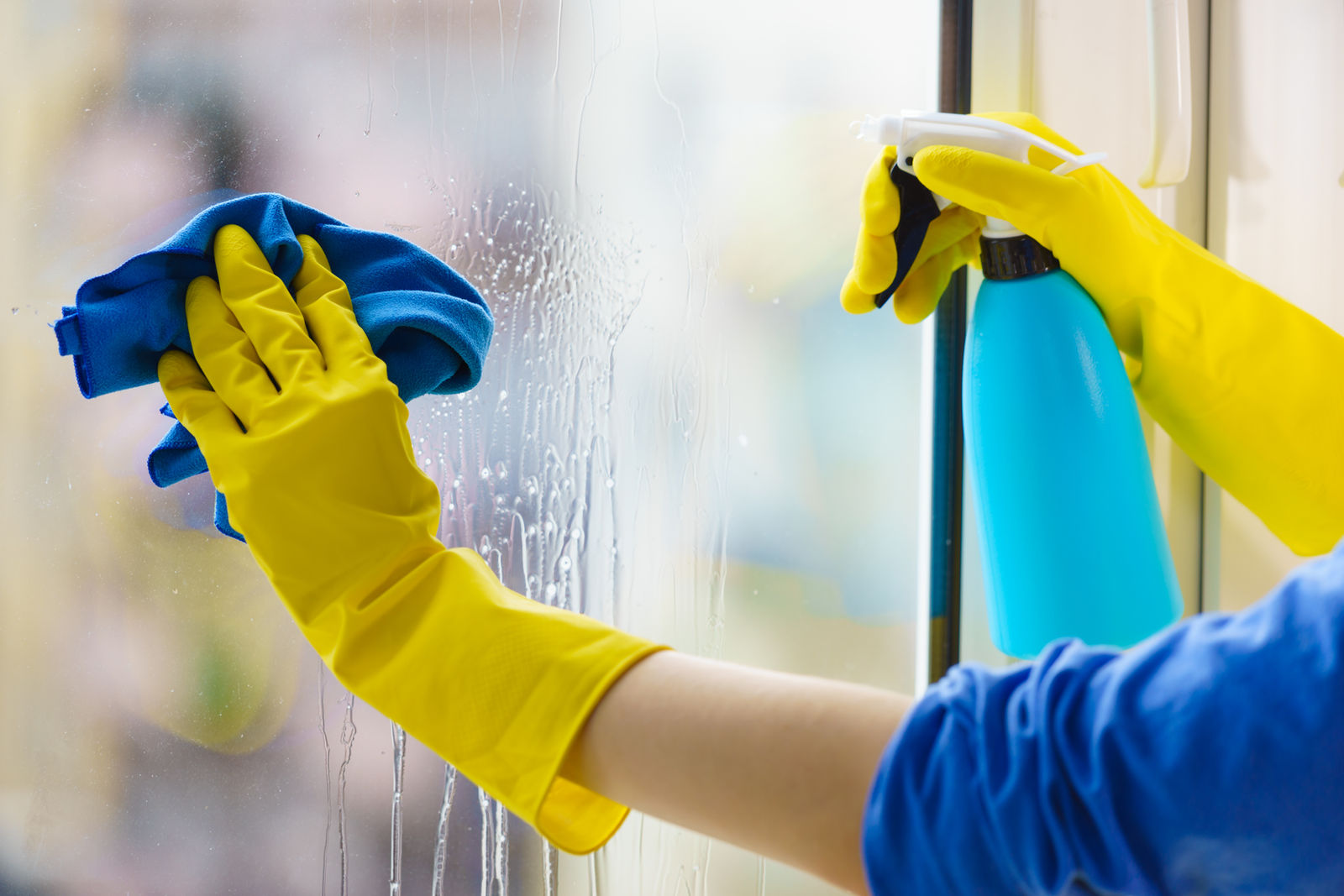 Fensterreinigung in Ingolstadt: Fensterscheibe wird mit Mikrofasertuch und Reinigungsmittel streifenfrei gesäubert